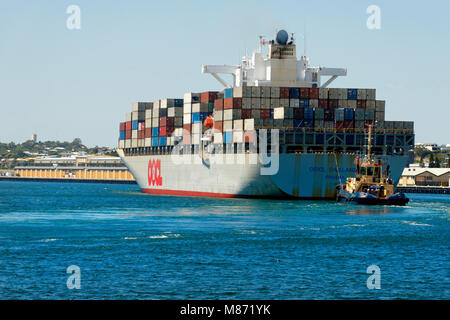 Container ship OOCL OAKLAND (Panama) with tug boat at the stern entering Fremantla harbour, Fremantle, Western Australia Stock Photo