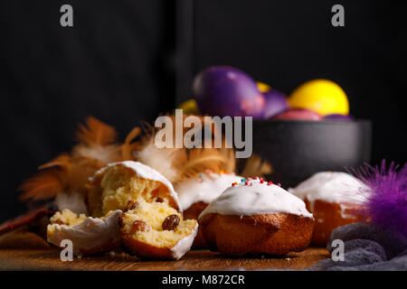 Baking in white glaze and the original painted eggs in a refined ceramic cup. Still-life on a wooden background. Stock Photo