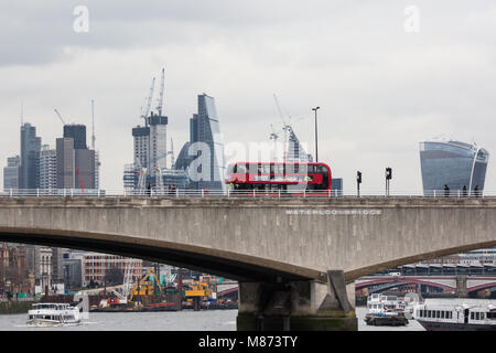 London, UK. 13th March, 2018. A doubledecker bus crosses Waterloo bridge on a cloudy day with St Paul's Cathedral and the City of London behind. Stock Photo