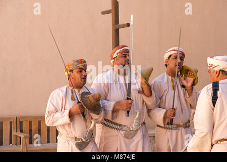 Nizwa, Oman - Omani men dancing a traditional sword dance at Nizwa Fort Stock Photo