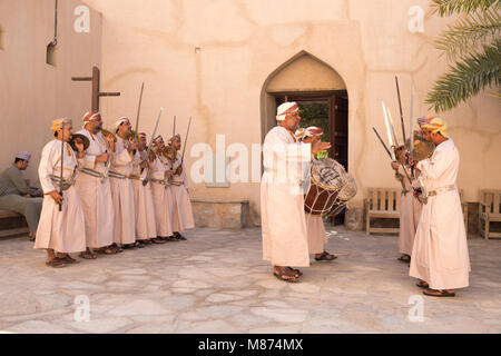 Nizwa, Oman - Omani men dancing a traditional sword dance at Nizwa Fort Stock Photo