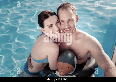 Funny girlfriend and boyfriend grimacing in swimming pool Stock Photo