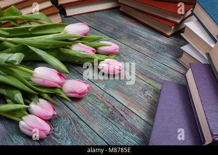 Pink tulips with books on wooden background Stock Photo