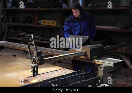 St. Petersburg, Russia - May 30, 2017: Operator makes cutting metal plate using a CNC plasma cutter machine. Stock Photo