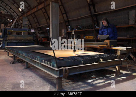 St. Petersburg, Russia - May 30, 2017: The worker stands at the control panel during plasma cutting of a metal plate. Stock Photo