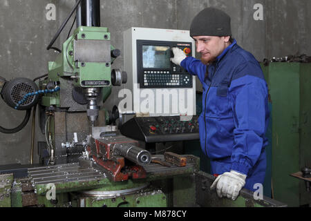 St. Petersburg, Russia - May 30, 2017: The worker controls the computerized milling machine through the control panel. Stock Photo