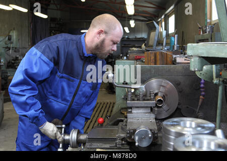 St. Petersburg, Russia - May 30, 2017: The turner makes a metal part on a mechanical lathe machine in workshop. Stock Photo