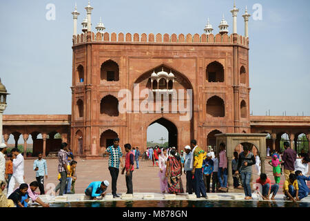 Muslim women and men washing at the basin inside courtyard of the Jama Masjid Mosque with the East gate, after the Friday prayer, Old Delhi, India Stock Photo