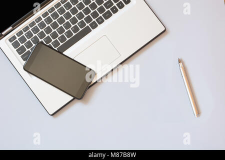 Open laptop and mobile on blue background. Business concept. Top view. Copy space. Stock Photo