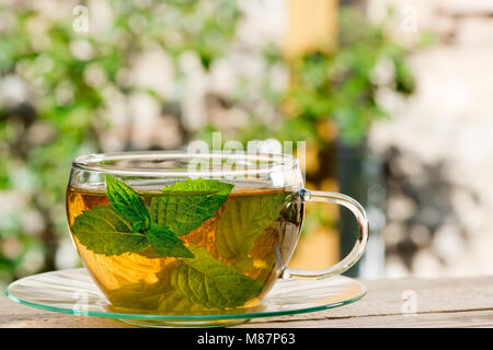 Glass of Tea on the Wooden Desk in the Garden Stock Photo