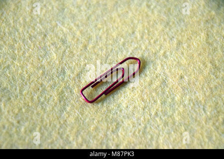 on red paperclip on yellow felt Background Stock Photo