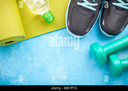 Yoga mat with sport shoes and dumbbells on pink background Stock Photo -  Alamy