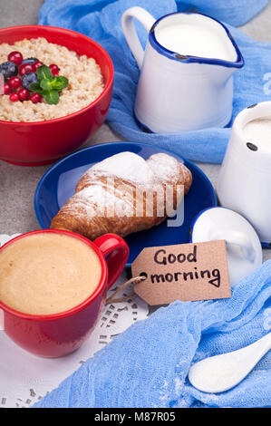 Traditional breakfast with oatmeal porridge, croissants, yogurt and coffee cup. Top view Stock Photo