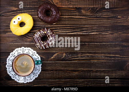 Coffee cup and donuts on wooden table. Breakfast oncept. Top view, copy space Stock Photo