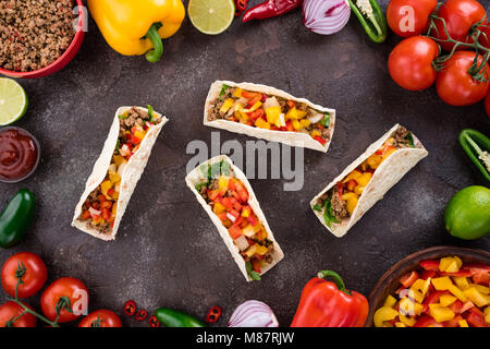 Mexican tacos with vegetables and meat. Ingredient for cooking tacos al pastor on concrete background. Top view Stock Photo