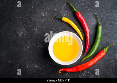 Spices. Chili pepper and olive oil on dark table top view and copy space Stock Photo