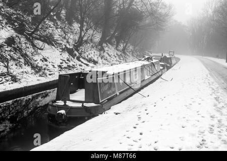 Narrowboats covered in snow are seen moored up on the Llangollen Canal in late winter Stock Photo