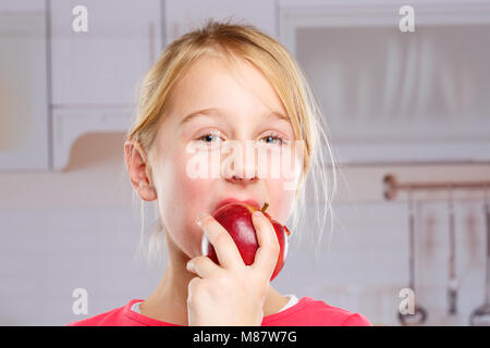 Girl child kid eating apple fruit autumn fall healthy kitchen Stock Photo
