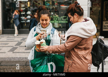 Prague, September 25, 2017: Two friends after shopping in the store stand on the street and take pictures of a traditional Czech dessert called Tridlo Stock Photo