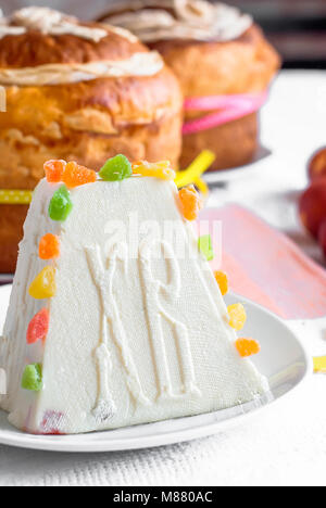 Easter food  background. Traditional curd Easter cake with candied fruits cookies  and Easter painted eggs  on the holiday light table Stock Photo