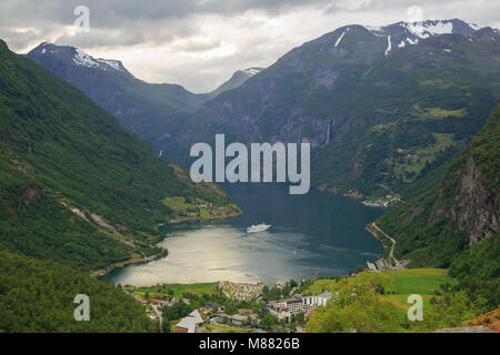 View from Flydalsjuvet lookout in Geiranger - the Geirangerfjord, Geiranger village and a cruise ship leaving the harbour Stock Photo