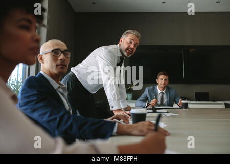 Business group having discussion at office meeting. Office workers brainstorming sharing ideas while sitting at conference table, Stock Photo