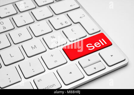 Red Sell button on a white keyboard isolated on a white background Stock Photo