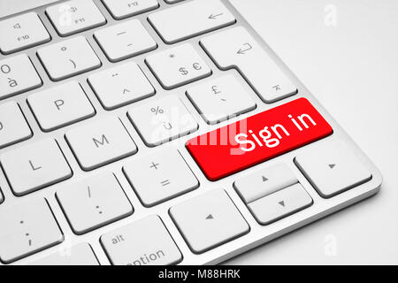 Red Sign in button on a white keyboard isolated on a white background Stock Photo