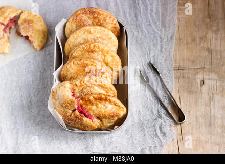 Crispy mini pies with apple and red currant. Rustic style. Stock Photo