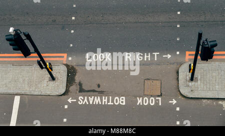 High perspective view of empty pedestrian crossing in the City of London. Iconic look left and look right signs painted to assist tourists of traffic  Stock Photo
