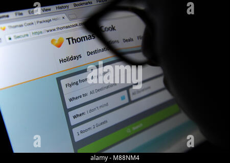 A woman looks at the Thomas Cook website on a computer Stock Photo