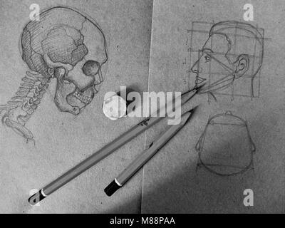 Pencil sketch of a skull and a human head in the old notebook black and white image Stock Photo