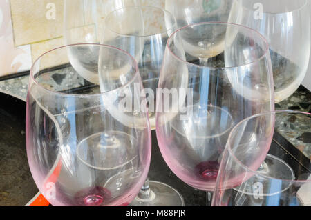 Dirty empty wine glasses and a red pan, after a good dinner, are waiting to be washed Stock Photo