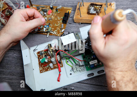 Work of the master on repair of electric equipment, it soldering details Stock Photo