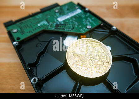 Cryptocurrency Golden Bitcoin on hard disk drive with blur background Stock Photo