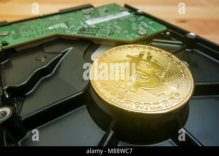 Cryptocurrency Golden Bitcoin on hard disk drive with blur background Stock Photo