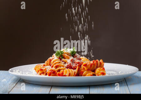 parmesan cheese falling on pasta Stock Photo
