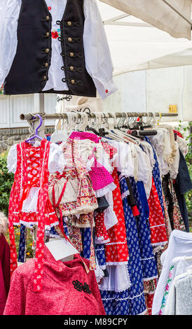 Beautiful bright national Hungarian clothes hanging on hangers in the street store Stock Photo