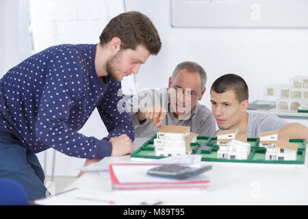 architects with house model and blueprint working in office Stock Photo
