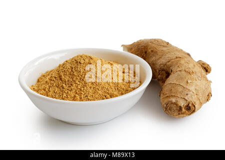 Finely ground dry ginger in white ceramic bowl isolated on white. Fresh whole root ginger. Stock Photo