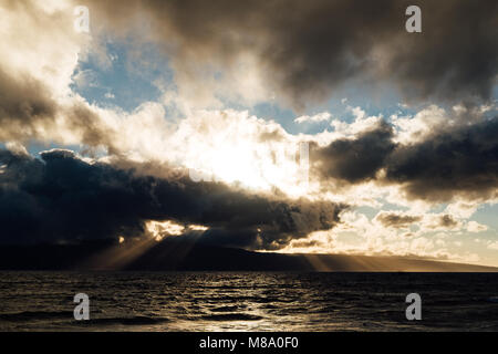 Partly Cloudy Sunset Over Maui with Rays of Sunshine shining Through Stock Photo