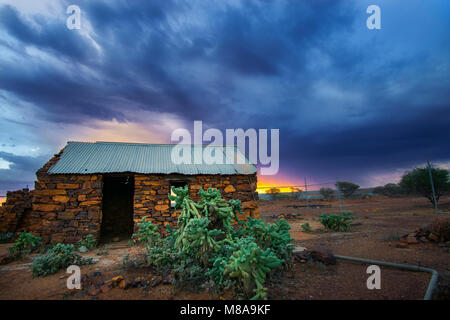 Storm approaching abandoned stone miners cottage at sunset, Mt Magnet goldfields, Western Australia Stock Photo
