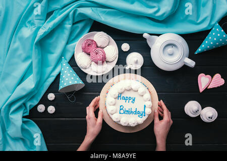 woman putting birthday cake on table Stock Photo