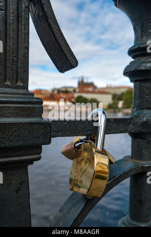 Love locks on a rail in Prague In the background, defoccused is Prague Castle Stock Photo