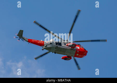 A British Royal Navy Westland Sea King HU5 rescue helicopter flying over the Round Tower at the entrance to Portsmouth Harbour, UK on 25/7/14. Stock Photo