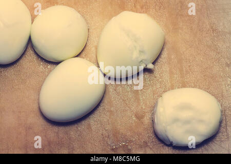 Five white boiled eggs for ingredients lie on a cutting board in the kitchen. Stock Photo