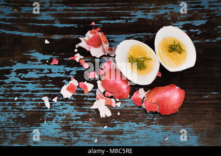 Colorful easter egg. Background with easter eggs cut in half with green dill. two halves. Red boiled egg in a red shell. Traditional Easter Breakfast  Stock Photo