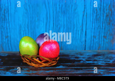 Easter painted in different colors eggs on a blue wooden table on vintage background. Stock Photo