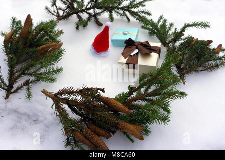 Christmas gift boxes in kraft paper and spruce branches on snow-covered background Stock Photo