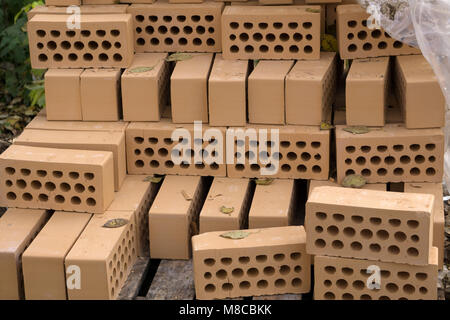 A stack of red bricks on a white background with a pointing trowel Stock Photo